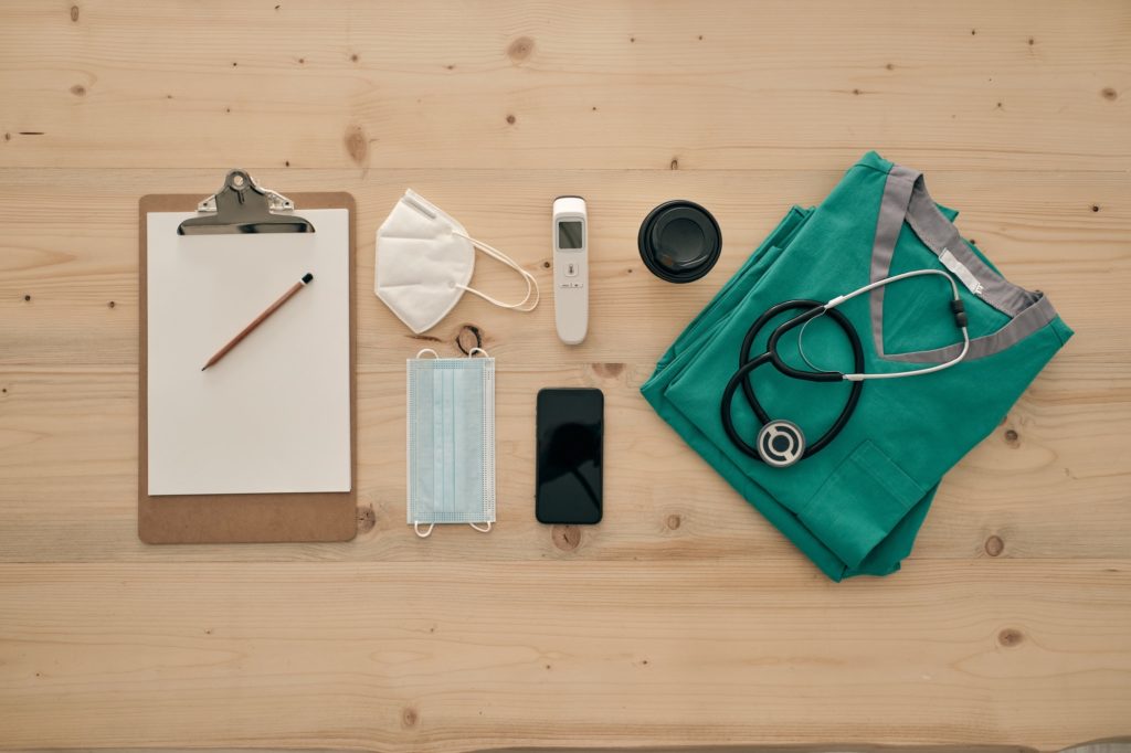 Medical equipment with smartphone and clipboard on table